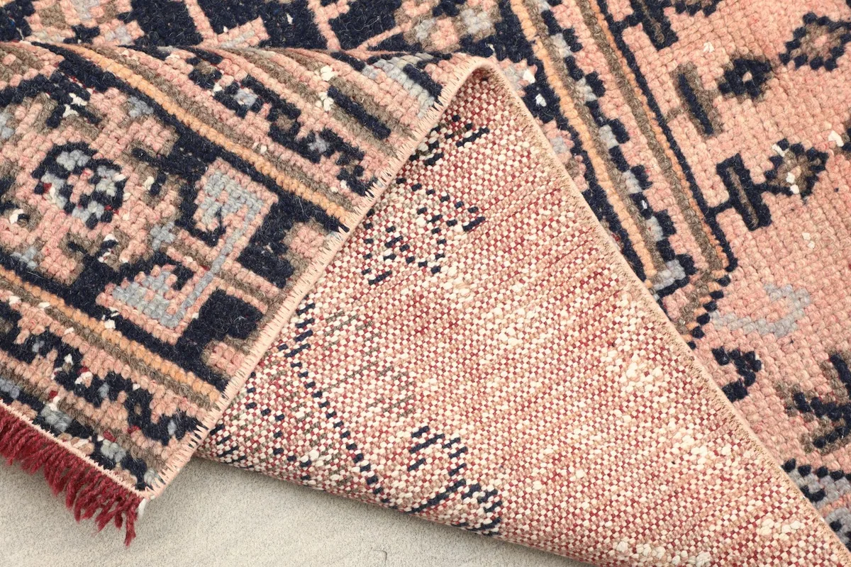View of the back of the hand-knotted rug, showing the cotton foundation and the reverse of the patterns.