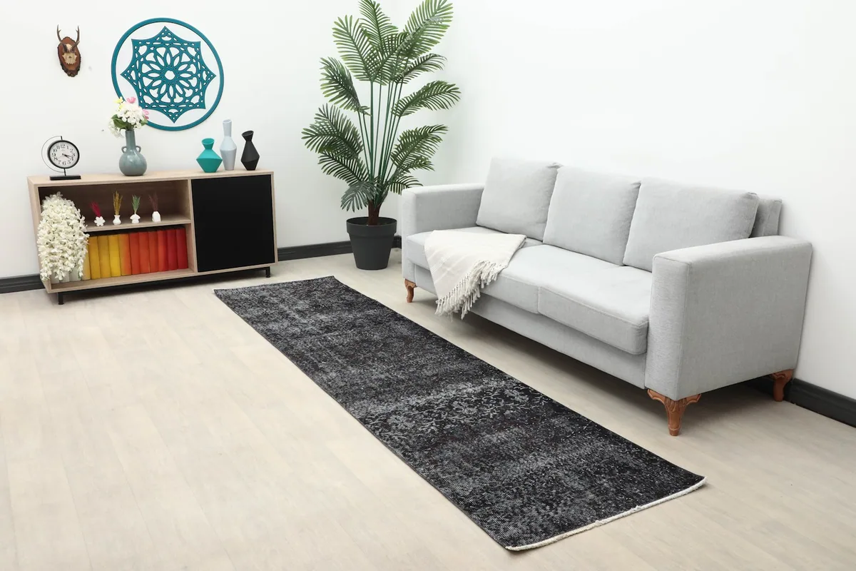 Wide shot of the charcoal runner rug in a modern living space with light flooring and furniture