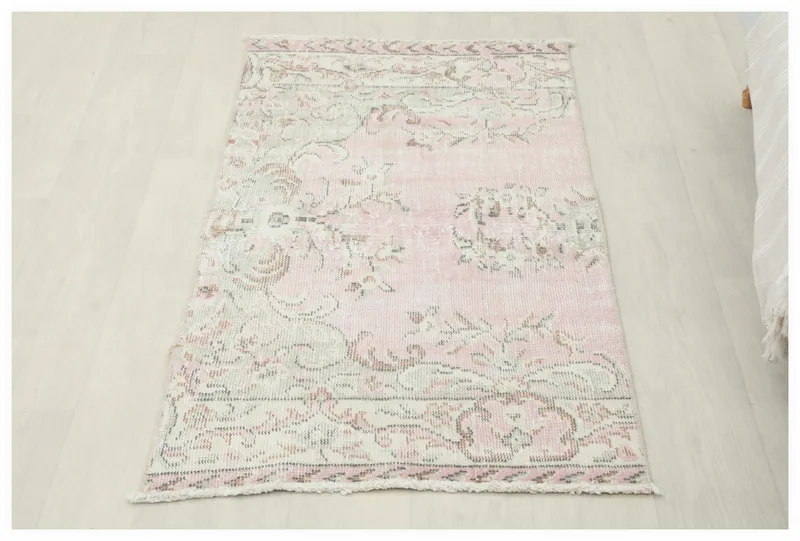 Full overhead view of the 2x5 vintage rose beige botanical rug on a white background