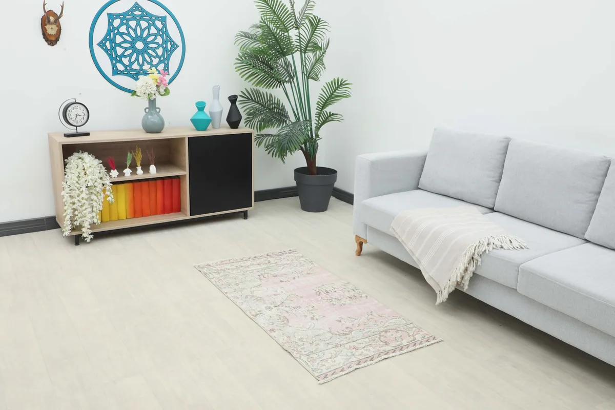 Vintage rose beige rug placed in a modern living room setting with a light gray sofa