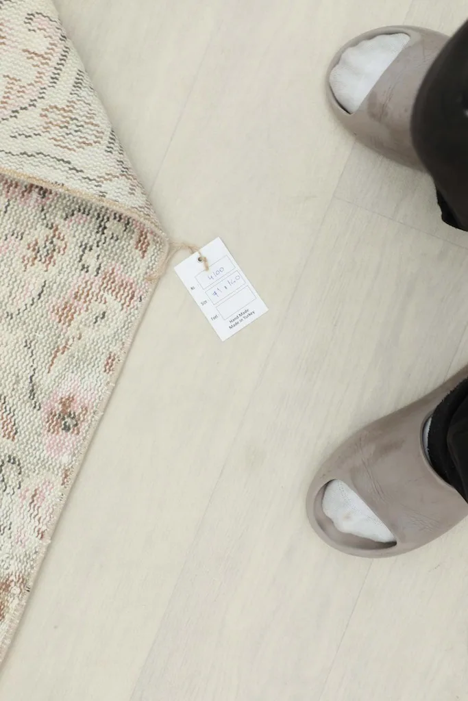 Overhead view of the rug's tag with product information, next to a person's feet for scale