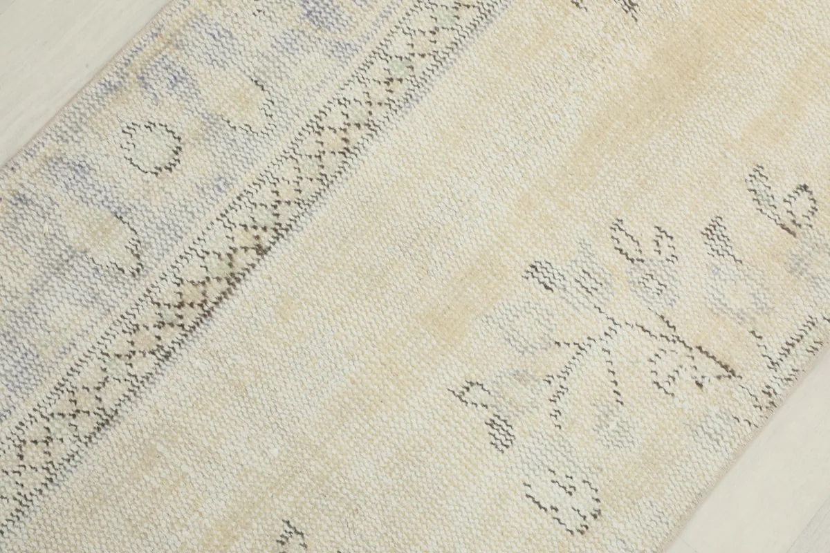 Detail view of the rug's patterns, including geometric shapes and subtle blue hues