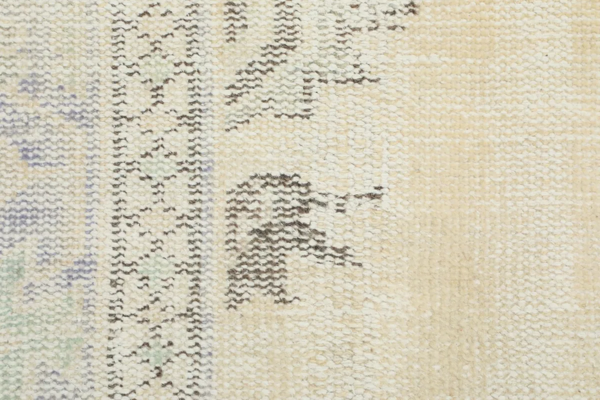 Macro detail of the hand-knotted wool pile and cotton foundation, showing weave and color variation