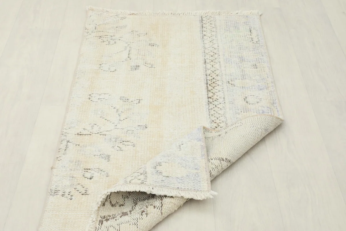 View of the rug folded to show the back side of the hand-knotted wool and cotton foundation