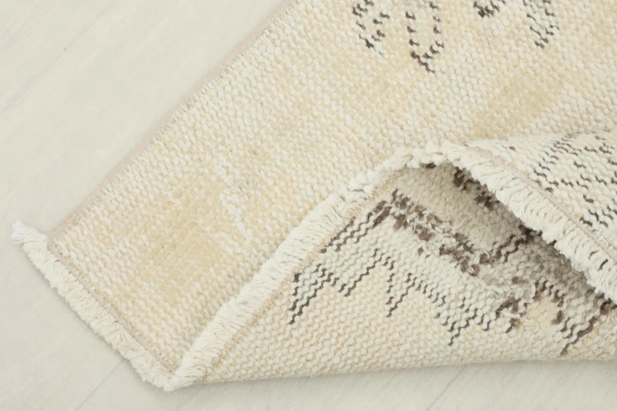 Detail of the rug's fringe and edge, showing the hand-knotted finish