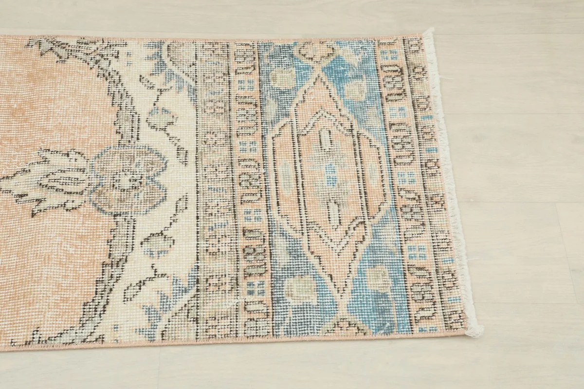 Close-up detail of the blue and rust geometric border and central motif on the rug