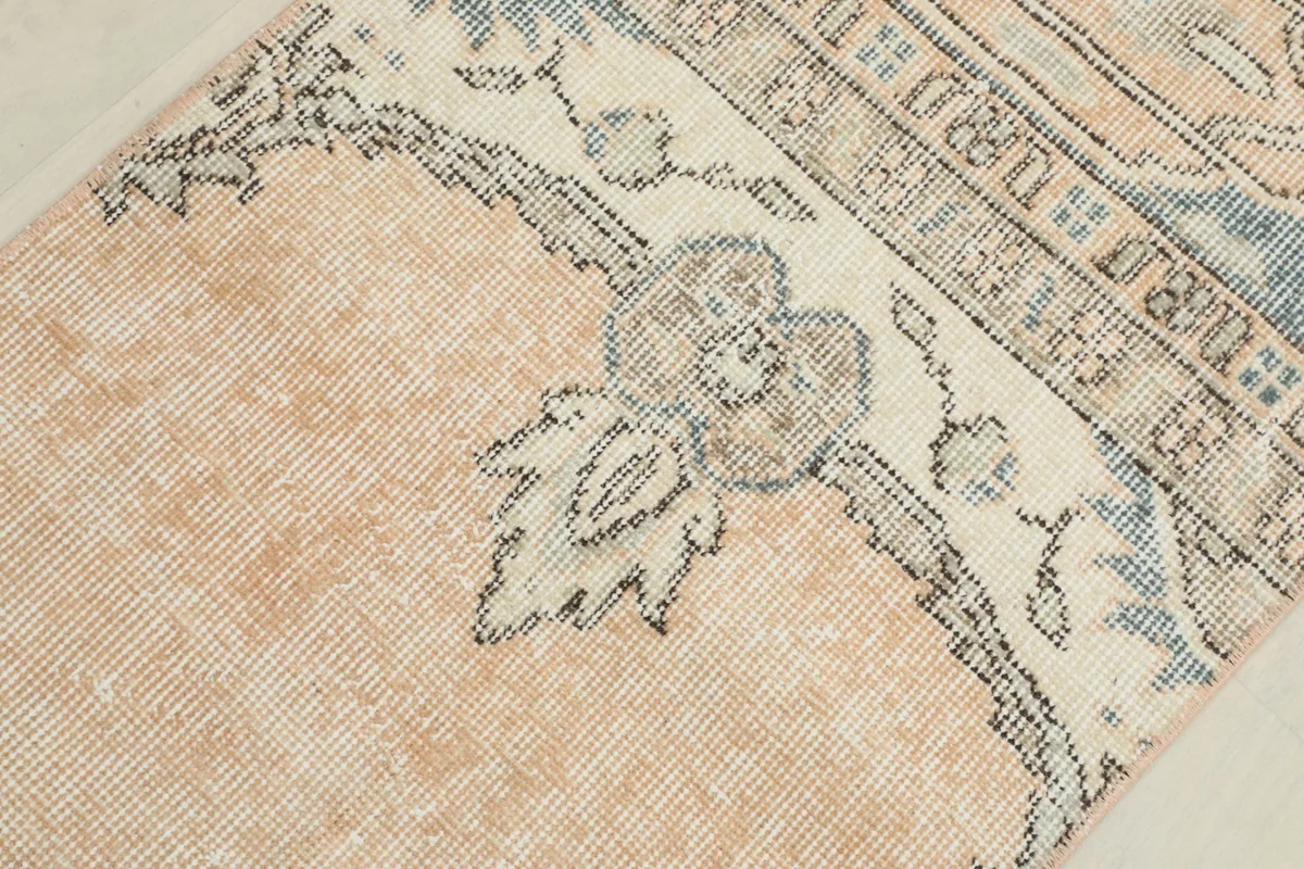 Detailed view of the central floral design and border transition on the hand-knotted rug