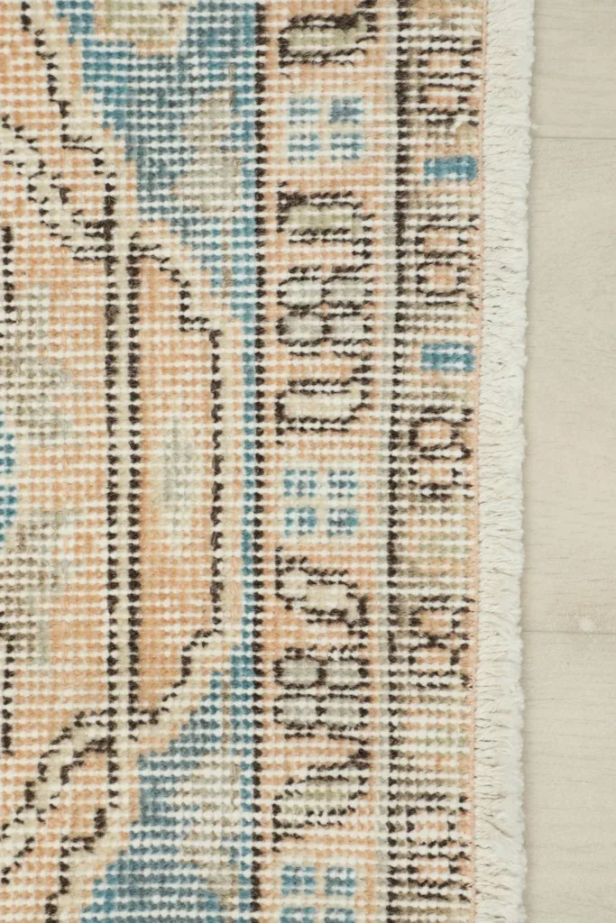 Detailed view of the rug's edge, showing the tight knotting and short fringe