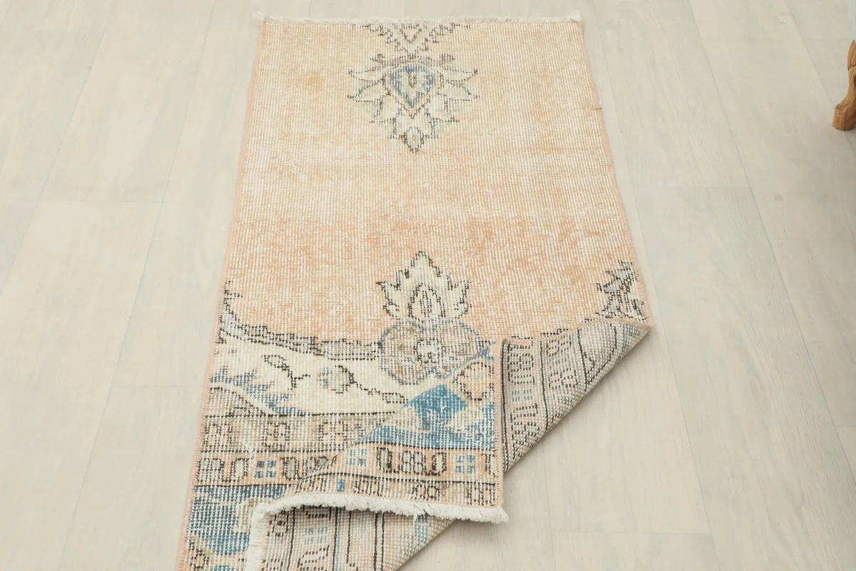 Rug partially folded, displaying the reverse side and the hand-knotted construction