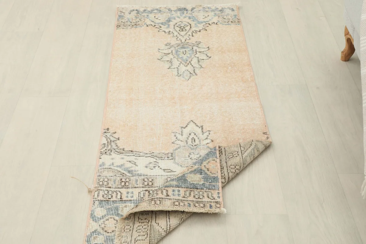 Runner rug partially folded, displaying the full design and flexibility of the vintage textile.