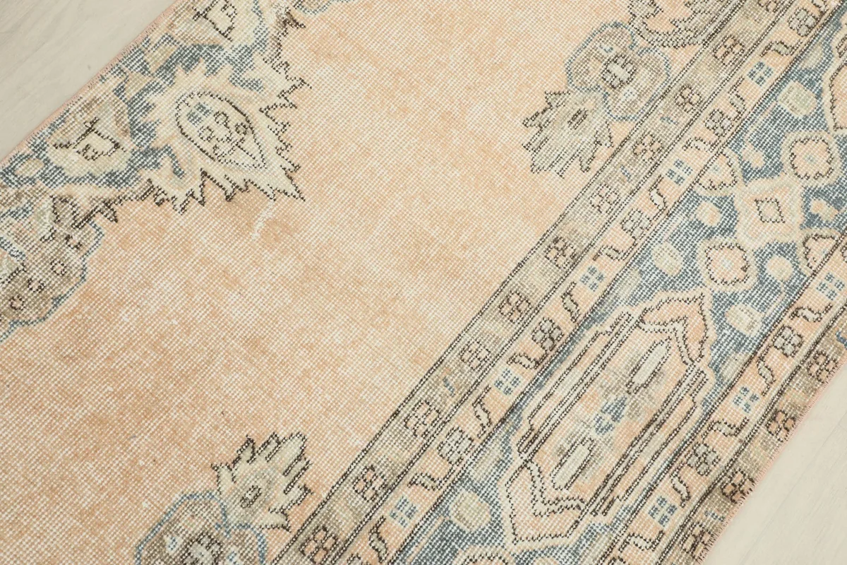 Overhead close-up of the rug's central field and one side of the border, showcasing floral motifs