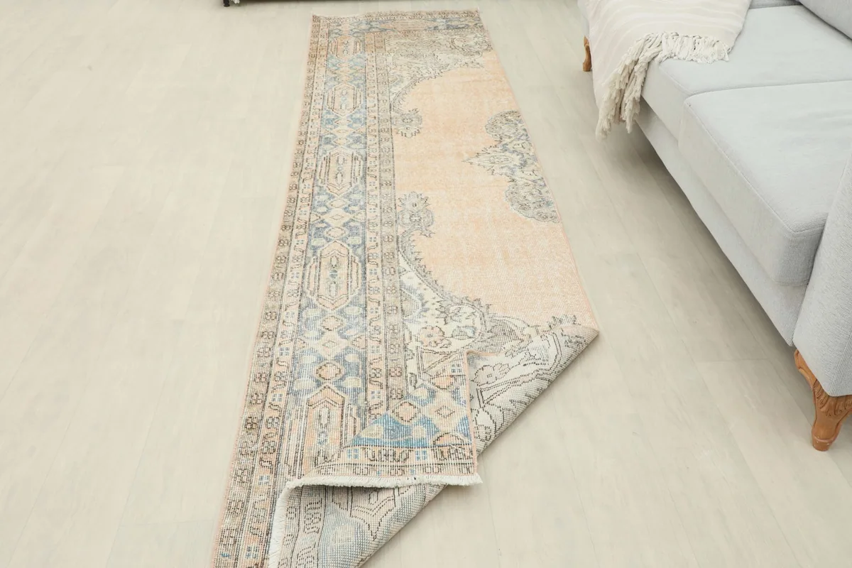 Runner rug partially folded, revealing the reverse side and cotton foundation