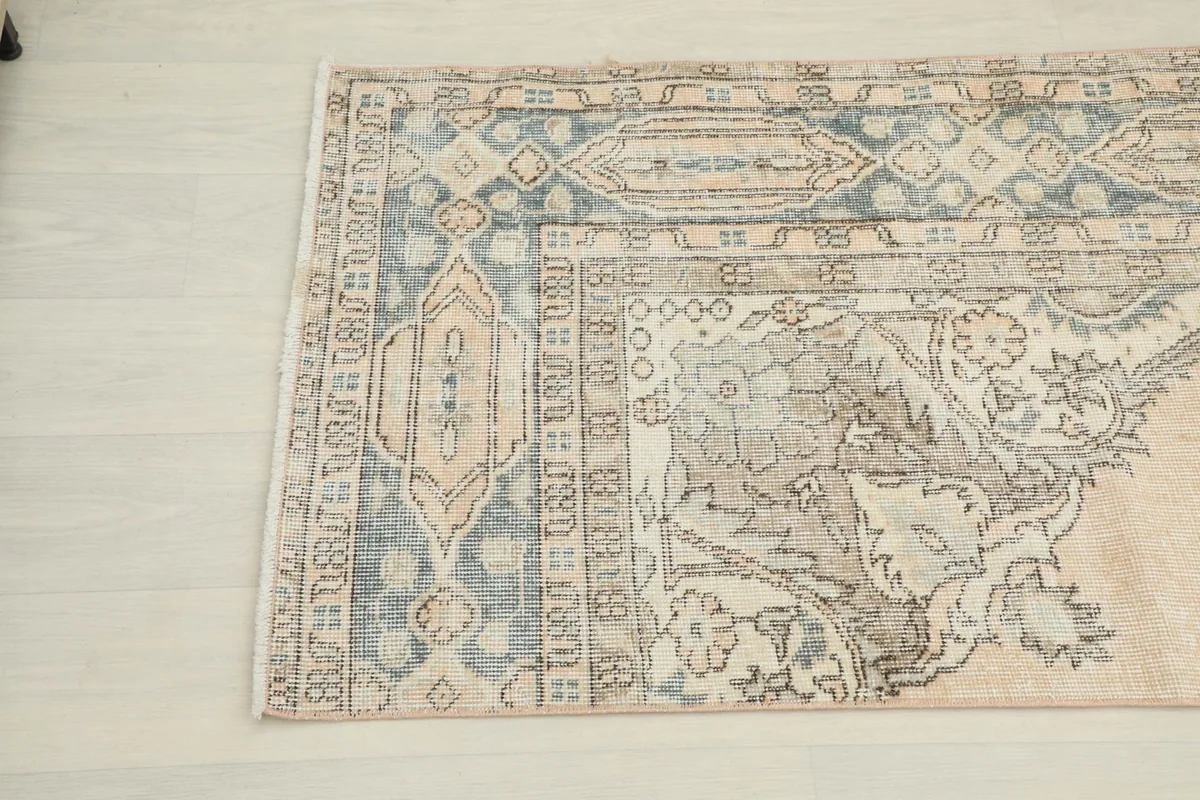 Angled view of the other end of the runner, displaying the faded floral motifs and border details.