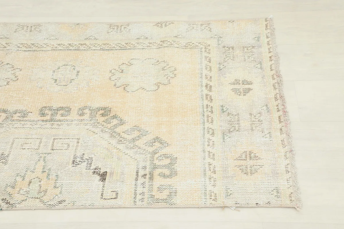 Close-up view of the upper right section of the rug, showing geometric patterns and border