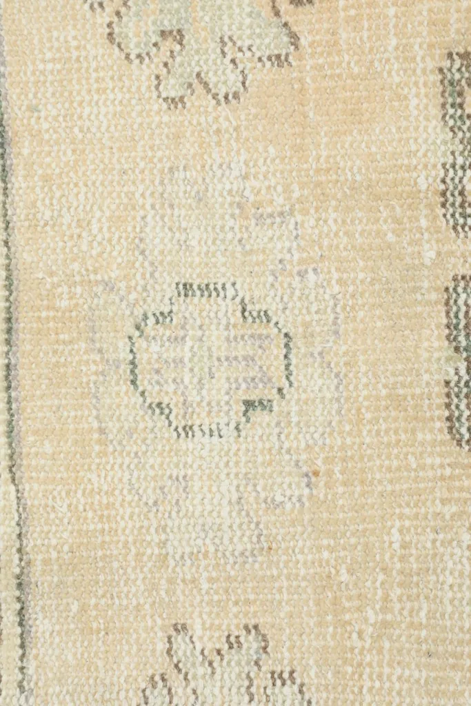 Extreme close-up showing the low wool pile texture and subtle color variations in the rug