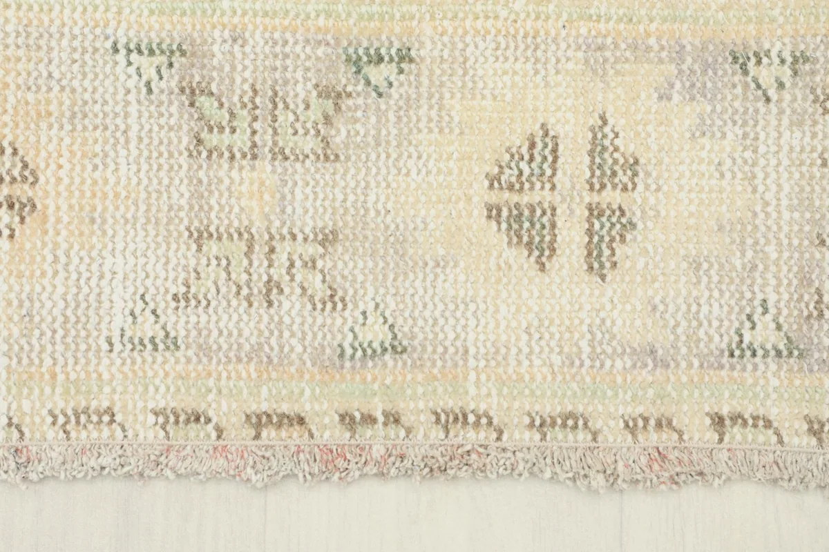 Close-up of the short, natural fringe and the lower border of the vintage hand-knotted rug