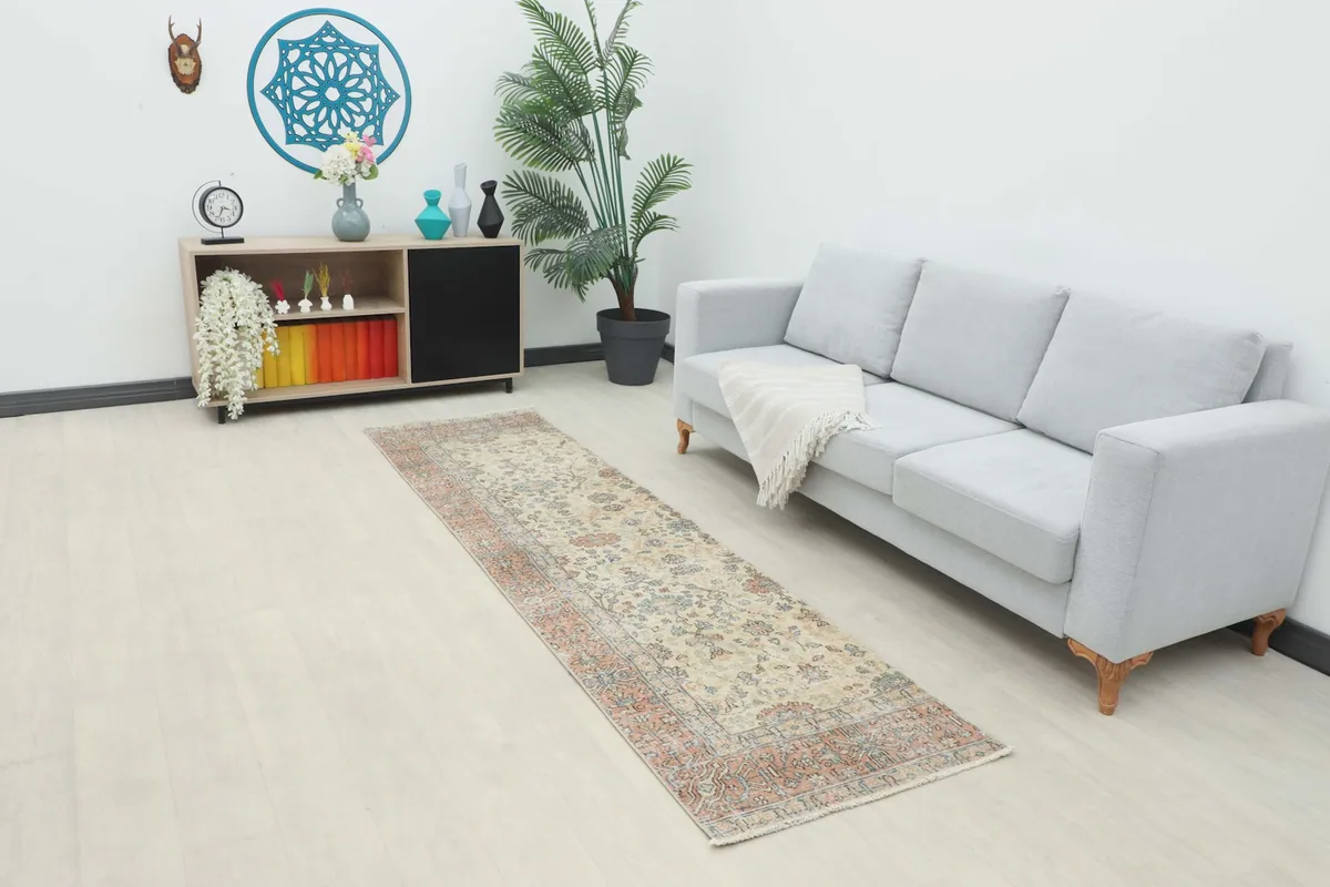 Ivory and rust runner in a modern hallway with a gray sofa and light wood floor