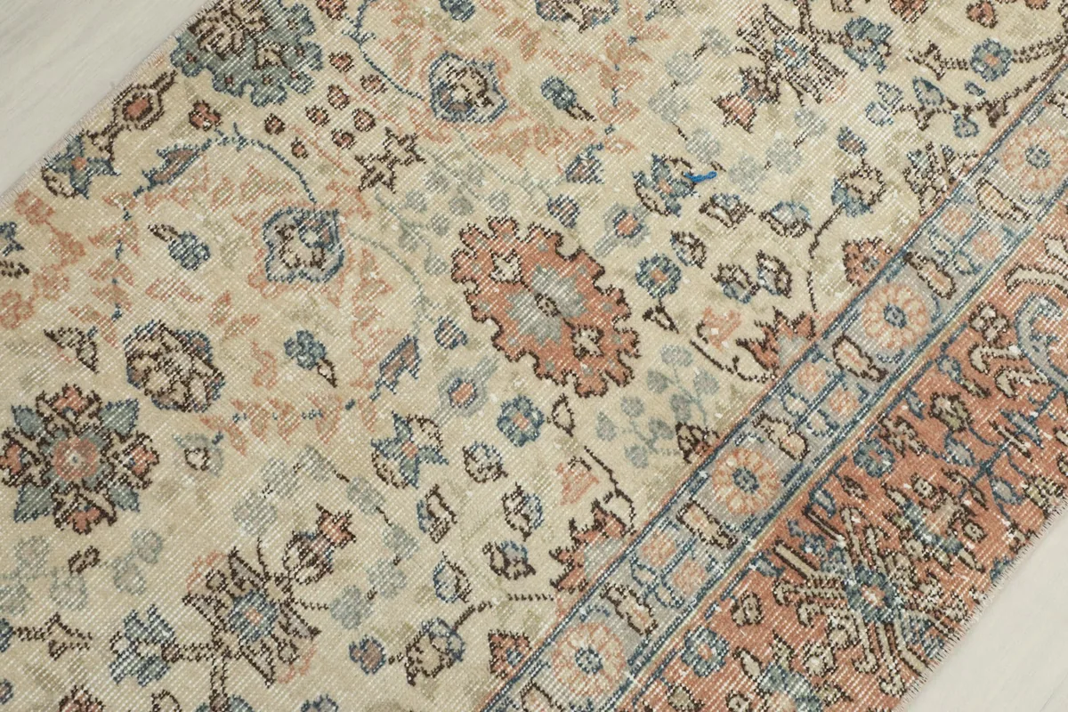 Close-up of the runner's center field, showing faded rust and blue floral designs