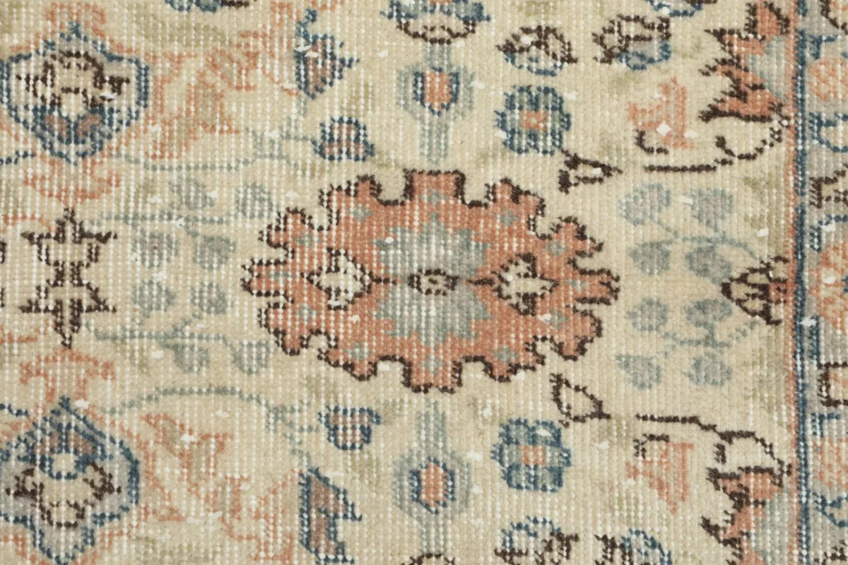 Macro view of the wool pile, revealing individual knots and muted colors