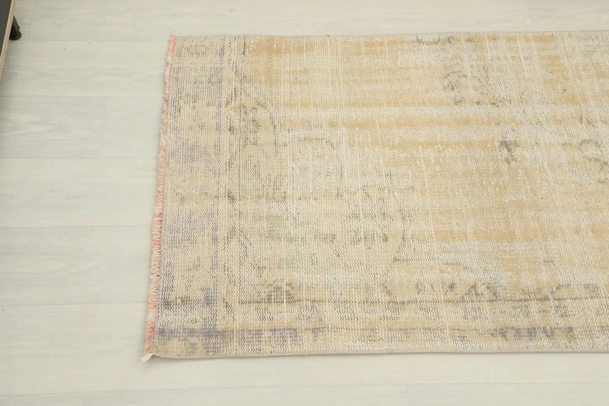 Angled view of the other end of the runner rug, highlighting its vintage patina