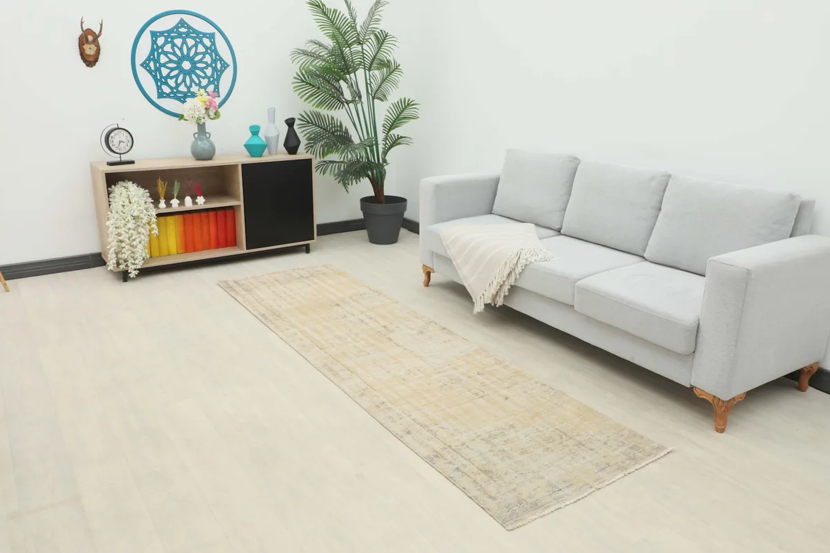 Runner rug placed in a living room setting next to a light gray sofa