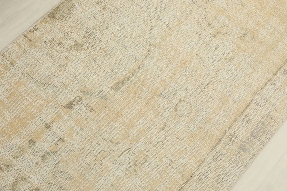 Detailed view of the faded geometric motifs and texture of the rug pile