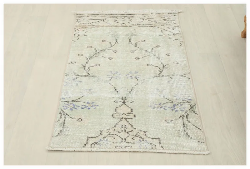 Full top view of the vintage cream and blue floral Anatolian rug on a white background.