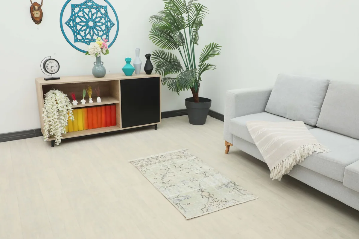 Vintage cream floral rug displayed in a modern living room setting with a gray sofa.