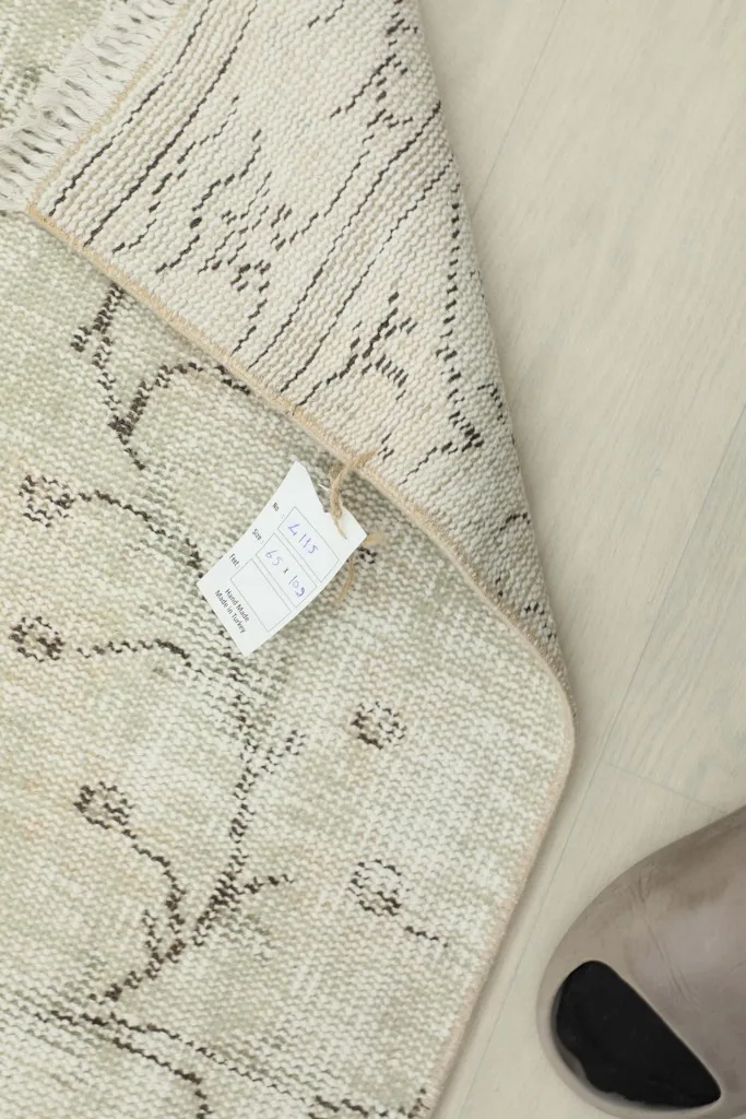 Close-up of the rug's reverse side, showing the hand-knotted construction and tag.