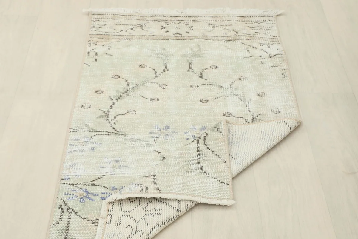 Overhead view of the rug with a corner folded, showing the full design and back.