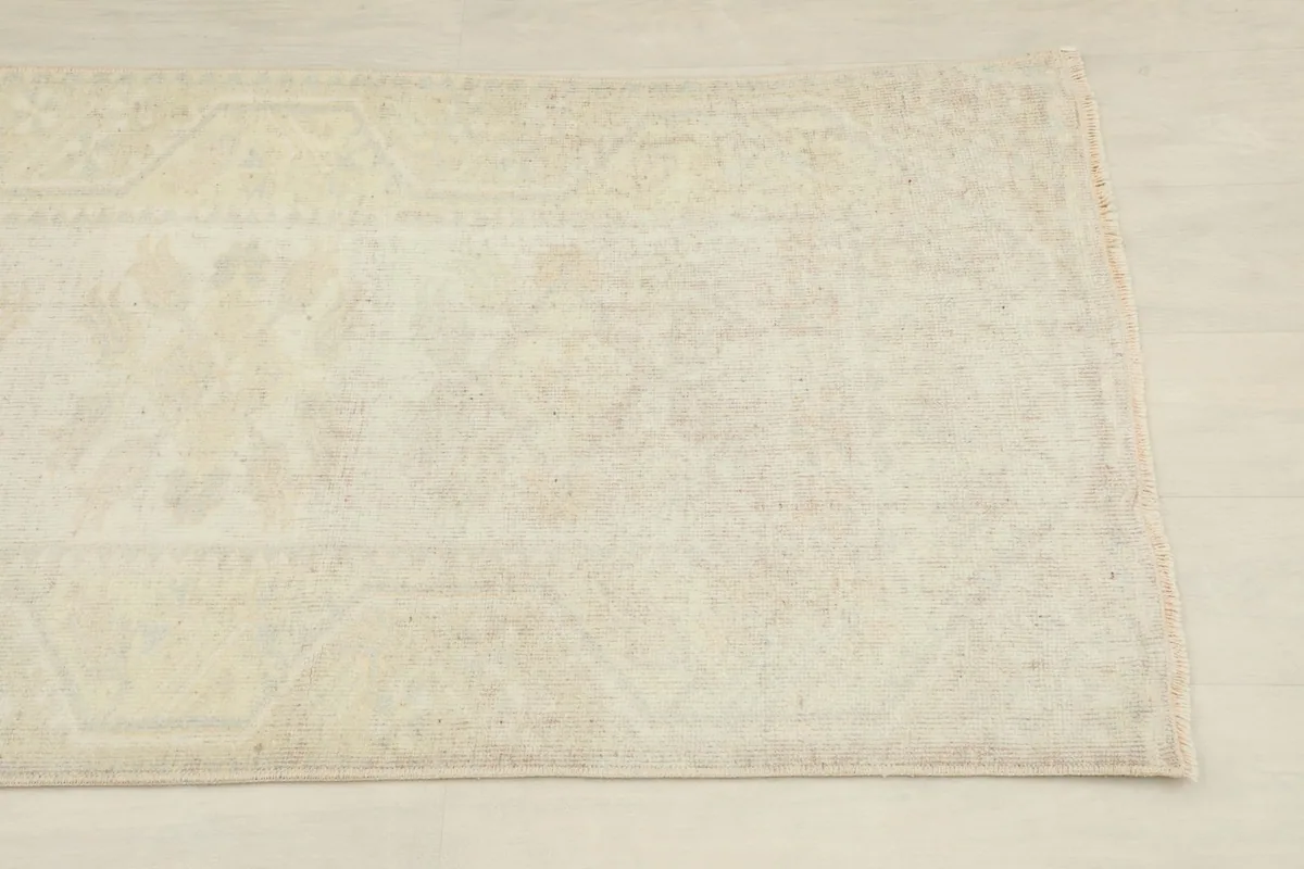 Close-up of the subtle geometric patterns and faded colors on the cream runner's surface.