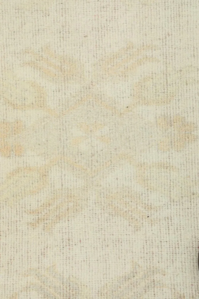 Close-up of the low wool pile and the hand-knotted texture of the cream runner.