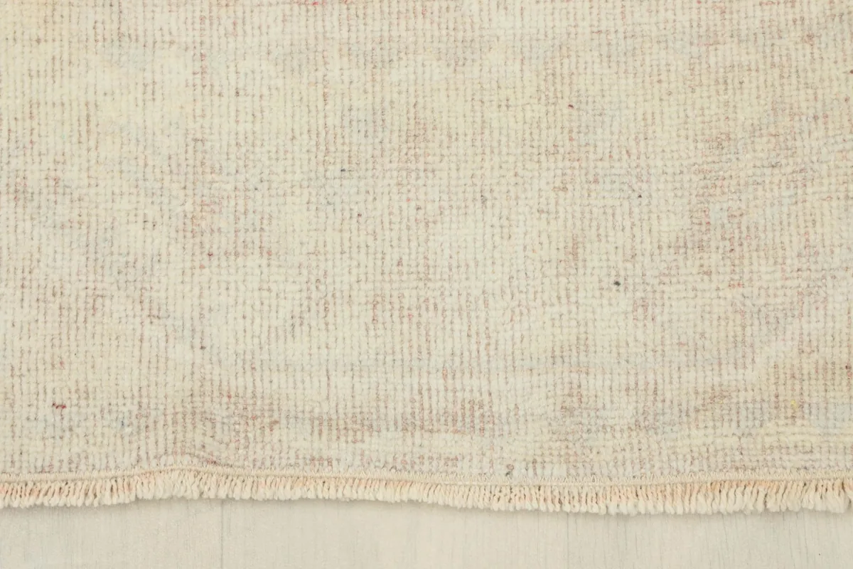 View of the short, natural cotton fringe and the back weave visible at the end of the runner.