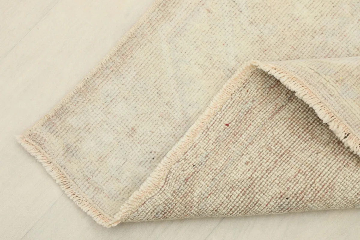 Folded corner of the runner showing the wool pile on the front and the cotton foundation on the back.