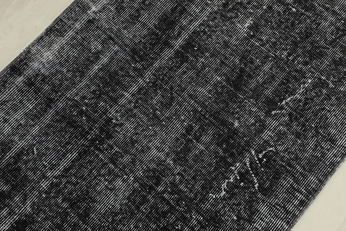 Detailed view of the distressed pattern and varying shades of black and gray on the rug
