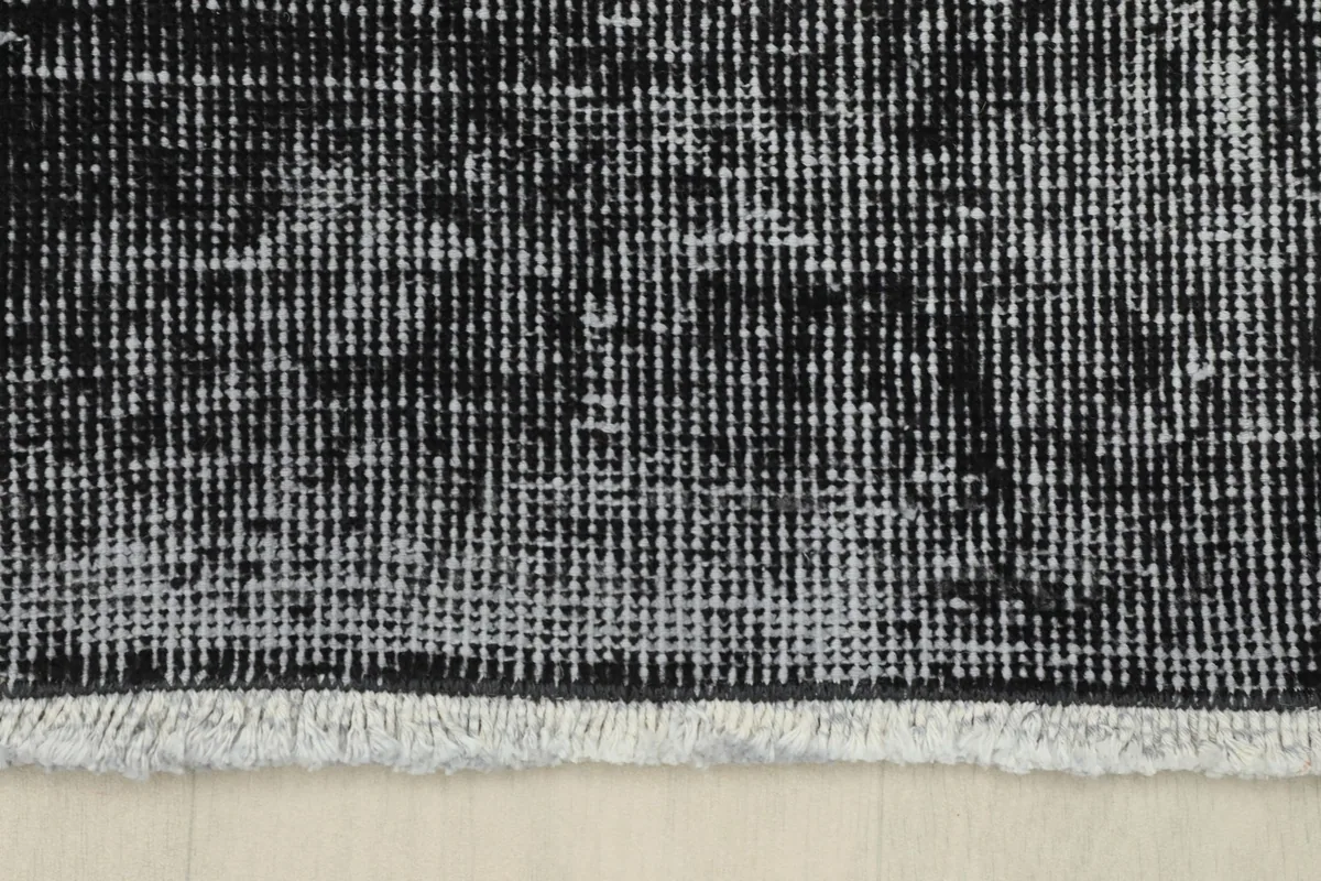 Close-up of the short, natural cotton fringes and the edge of the charcoal runner