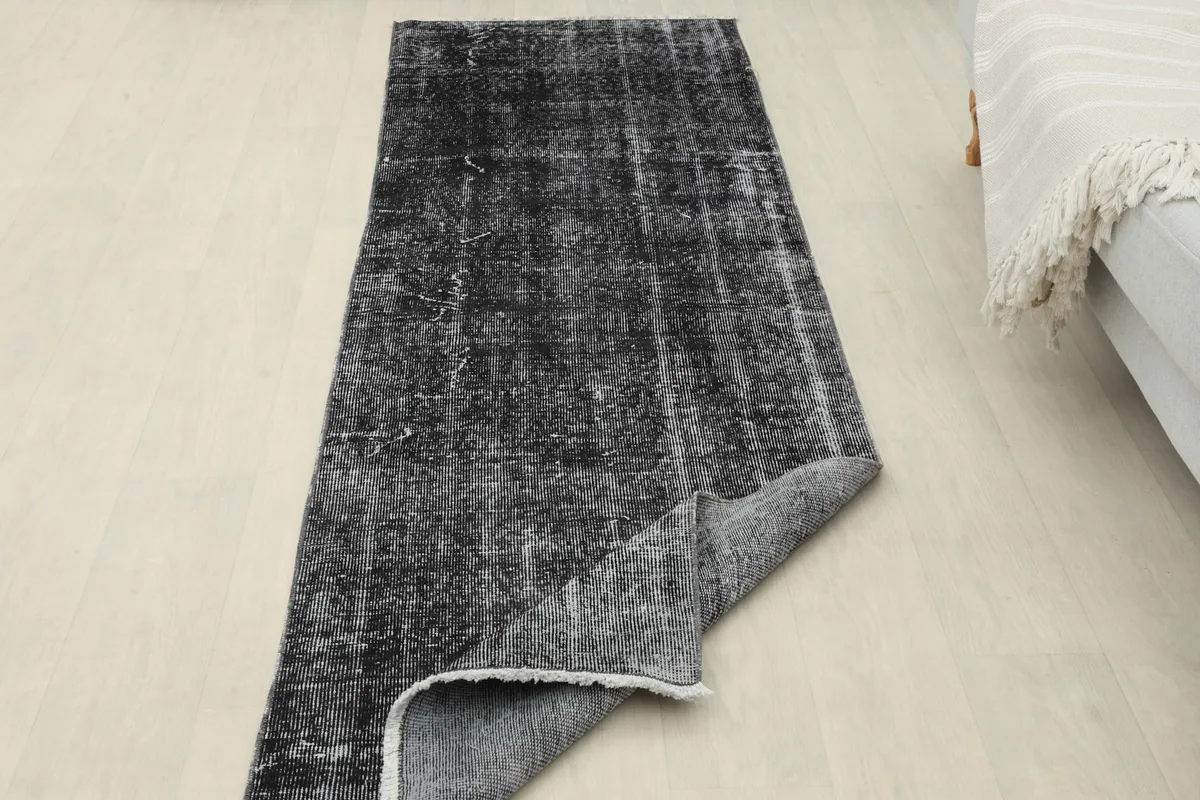 Runner rug with one end folded back, revealing the underside and showing its flexibility