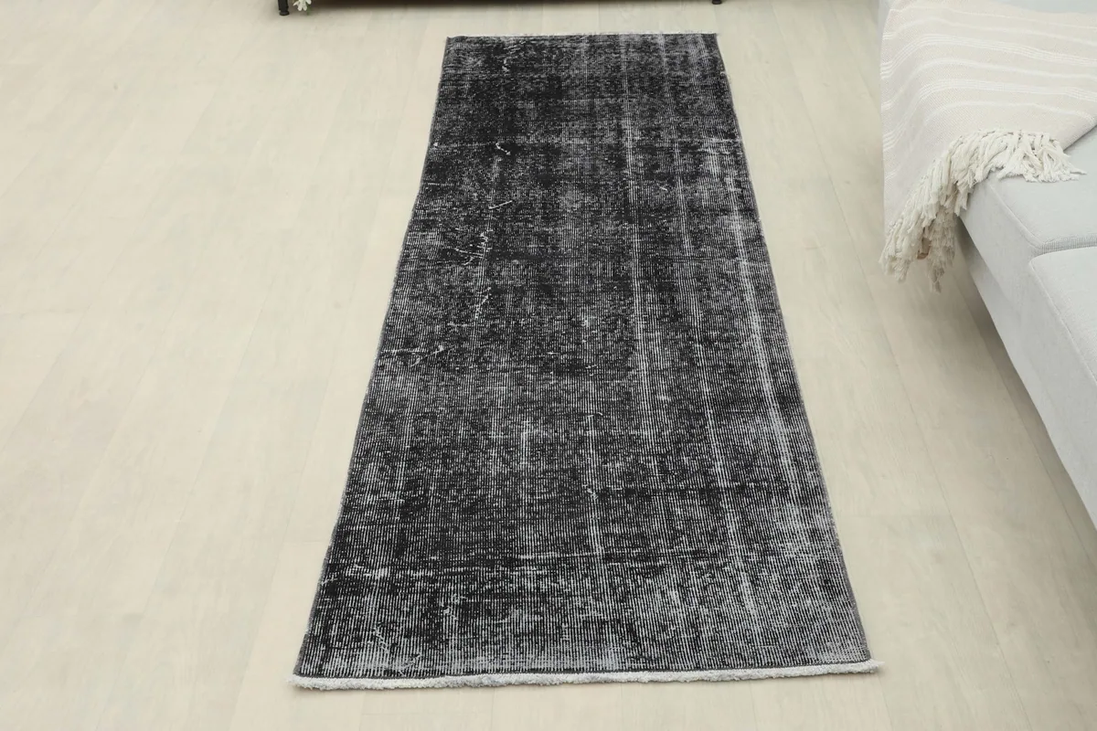 Overhead view of the distressed charcoal runner rug laid flat in a room