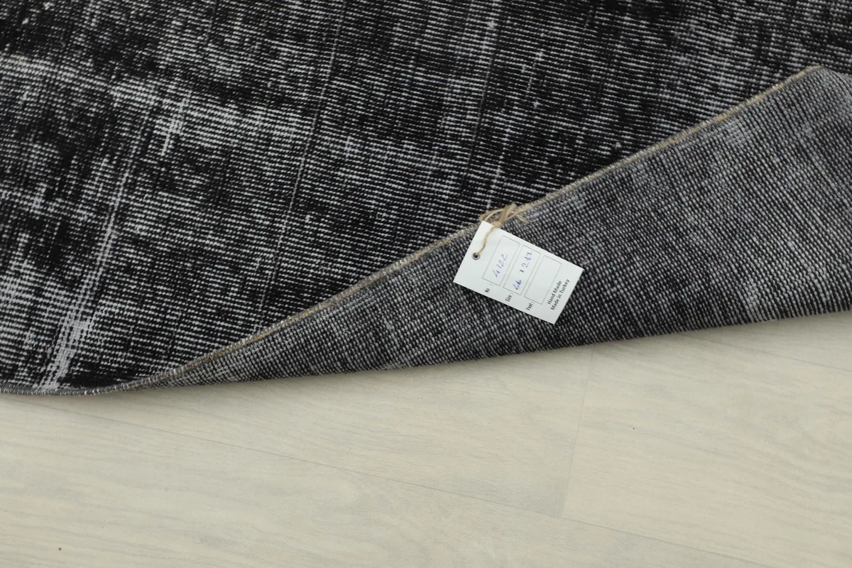 Underside of the rug with a tag, showing the tight knotting and craftsmanship