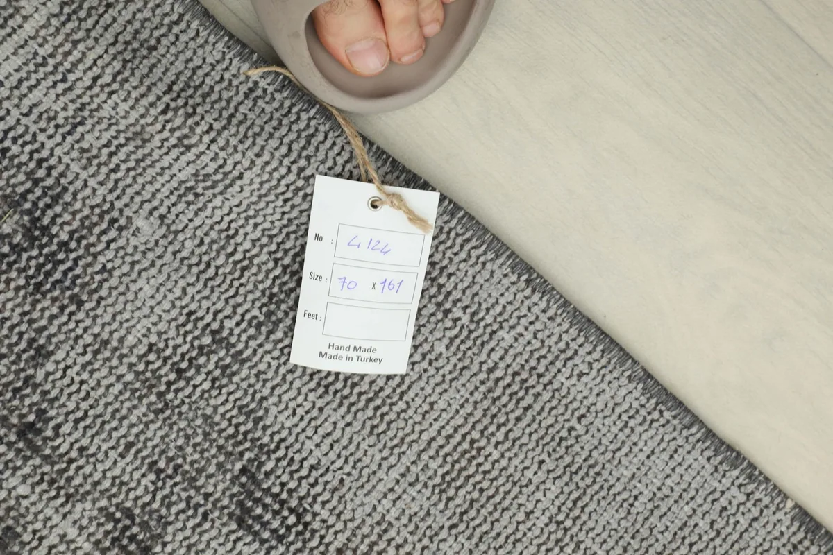 Overhead shot of the rug with a size tag, showing the 2'4" x 5'3" dimensions and hand-made origin.
