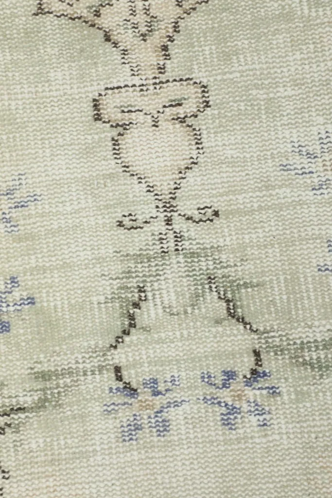 Extreme close-up showing the hand-knotted texture and faded blue and gray patterns