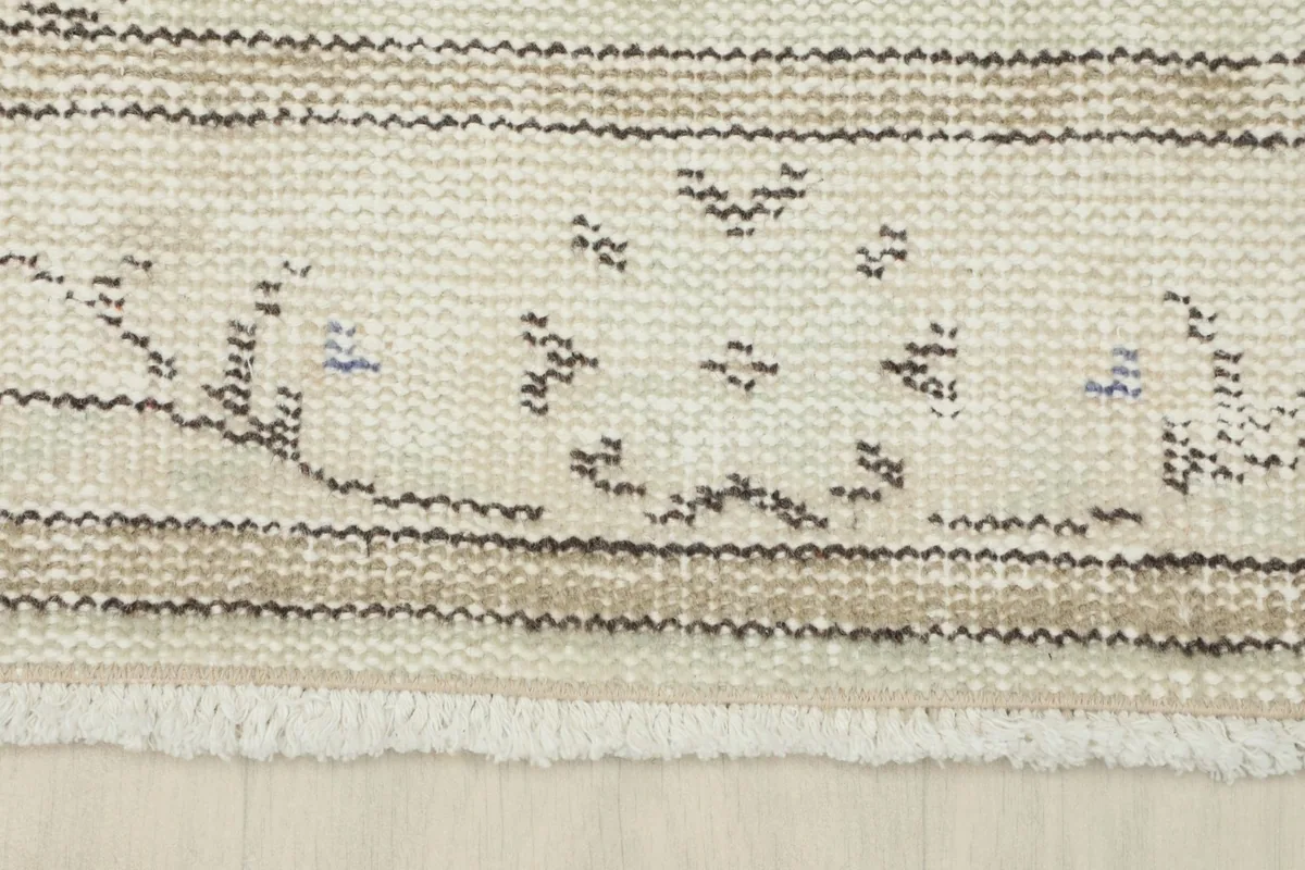 Detail of the rug's border showing the geometric pattern and fringe