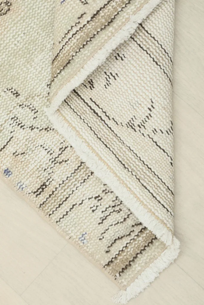 View of the rug's cotton foundation and the reverse side of the hand-knotted wool pile