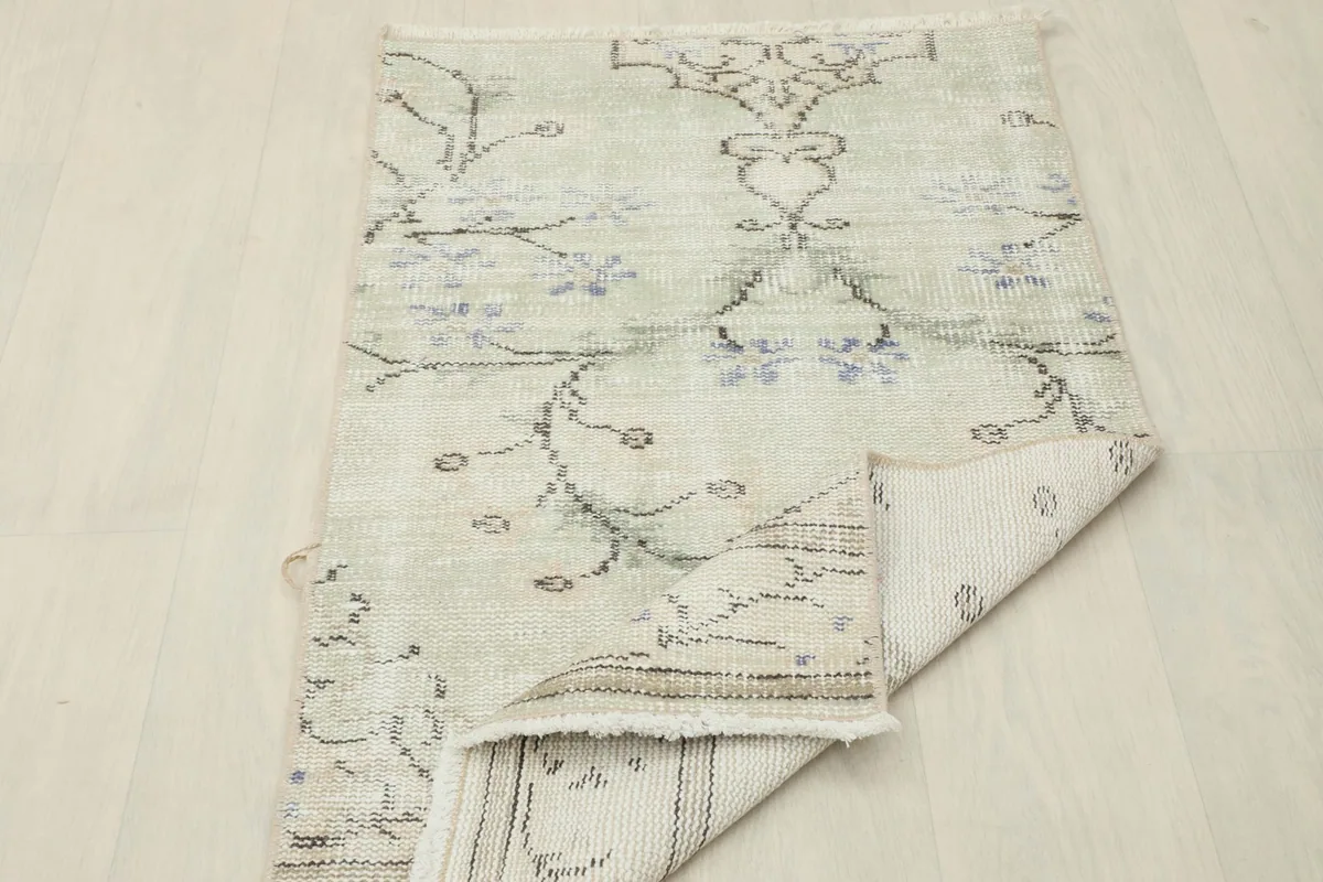 The rug partially folded to show the thickness and texture of the wool pile