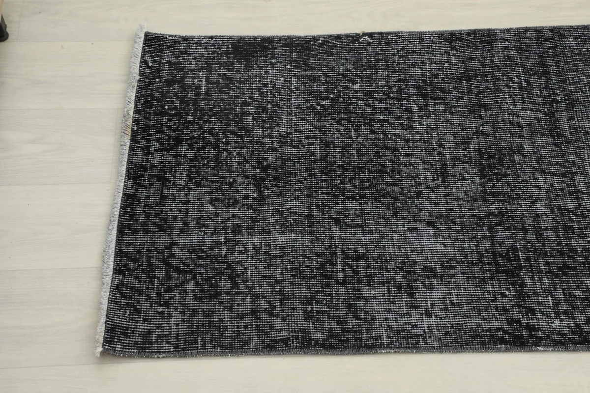 Angled view of the opposite end of the charcoal and gray runner, displaying the subtle variations in color.