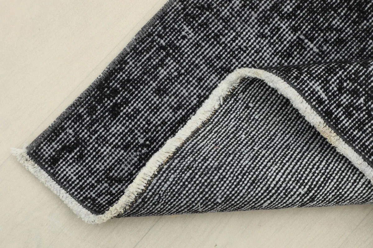Corner of the runner folded back, revealing the reverse side of the hand-knotted wool pile on cotton foundation.