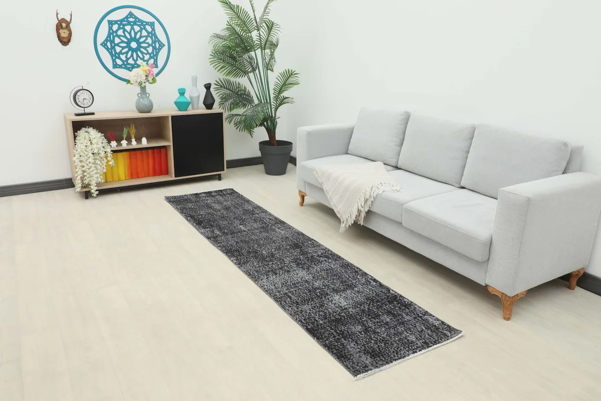 Charcoal runner rug placed in a modern living room setting with a light gray sofa