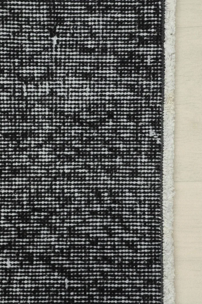 Edge detail of the charcoal runner rug, showing the professionally finished side