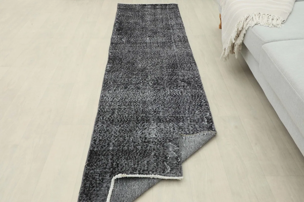 Runner rug with a corner folded back, showing the thickness and construction