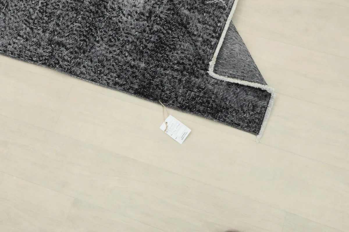 Rug corner with a product tag visible on the floor next to it